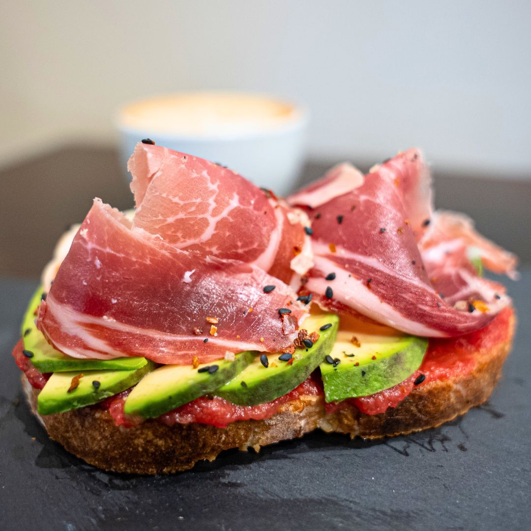 Tosta de tomate triturado, aguacate en láminas y jamón ibérico de bellota